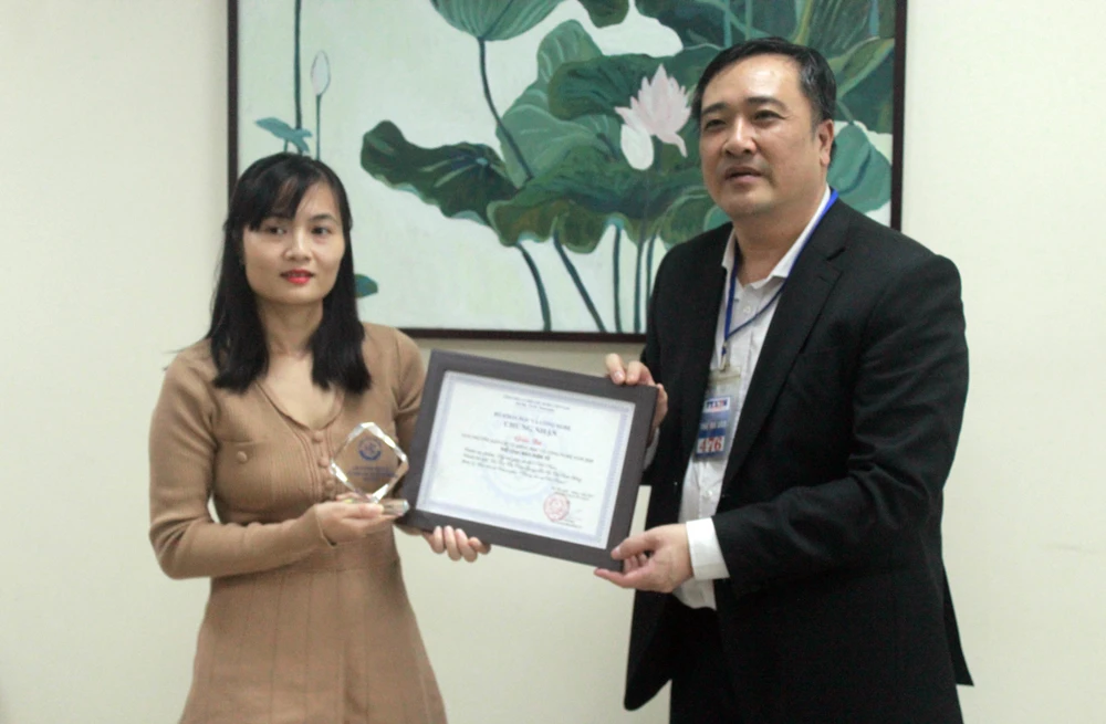 Tiến sỹ Trần Quang Tuấn, Giám đốc Trung tâm Nghiên cứu và Phát triển Truyền thông Khoa học và Công nghệ trao giải cho đại diện nhóm tác giả của Báo điện tử VietnamPlus. (Ảnh: PV/Vietnam+)
