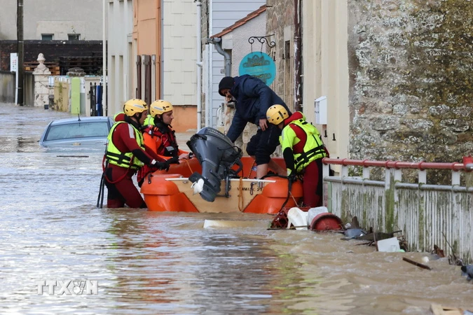 Lính cứu hỏa sơ tán người dân khỏi khu vực ngập lụt do mưa lớn ở Boulogne-sur-Mer, miền Bắc Pháp ngày 7/11 vừa qua. (Ảnh: AFP/TTXVN)