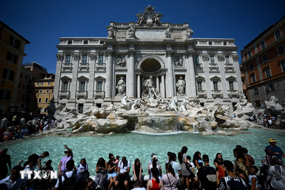 Khách du lịch giải nhiệt tại đài phun nước Barcaccia trong thời tiết nắng nóng gay gắt tại Rome, Italy, ngày 21/8/2023. (Ảnh: AFP/TTXVN)