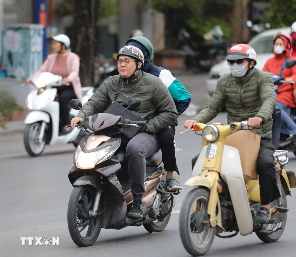 Không khí lạnh tràn về, khiến người dân Hà Nội phải mặc thêm áo ấm. (Ảnh: Thanh Tùng/TTXVN)