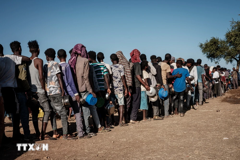 Người tị nạn xếp hàng chờ nhận lương thực cứu trợ tại Gedaref, Sudan. (Ảnh: AFP/TTXVN)