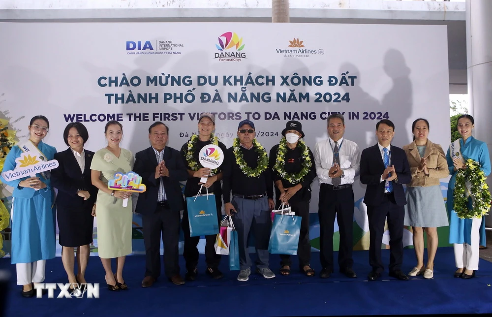 Tặng hoa, quà chúc mừng các du khách đầu tiên đến Đà Nẵng trong dịp Tết Dương lịch 2024 tại Sân bay Quốc tế Đà Nẵng. (Ảnh: Trần Lê Lâm/TTXVN)