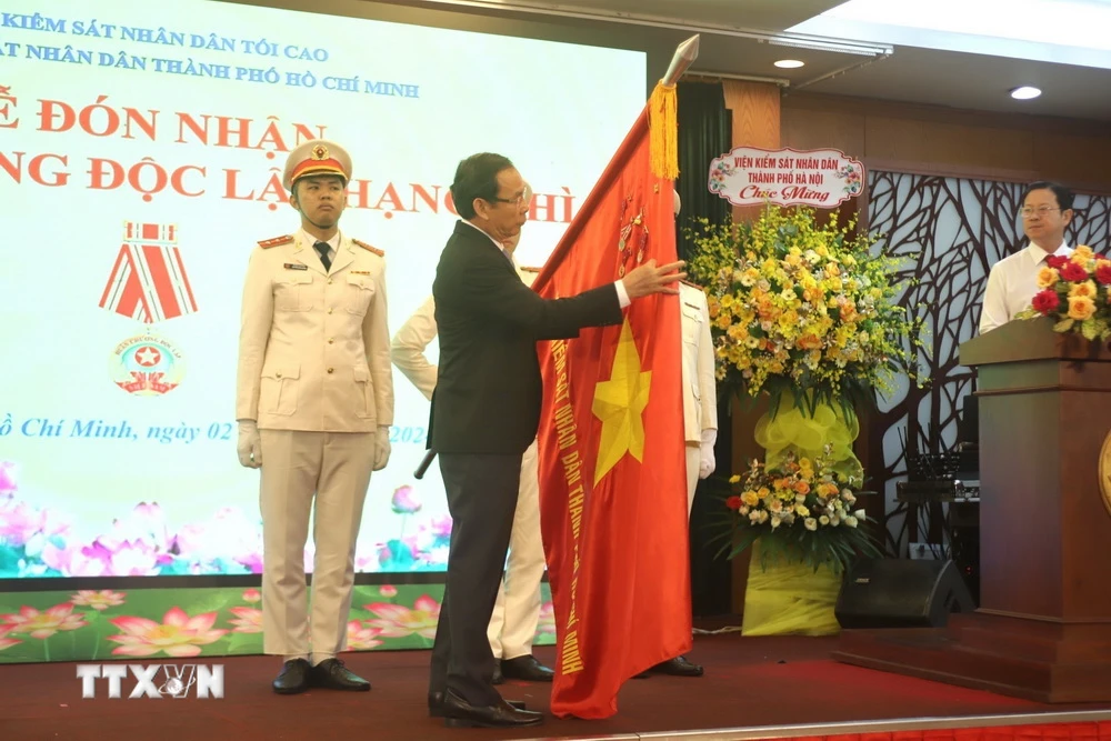 Ông Nguyễn Văn Nên, Bí thư Thành ủy Thành phố Hồ Chí Minh gắn Huân chương Độc lập hạng Nhì lên cờ truyền thống của đơn vị. (Ảnh: Thành Chung/TTXVN)