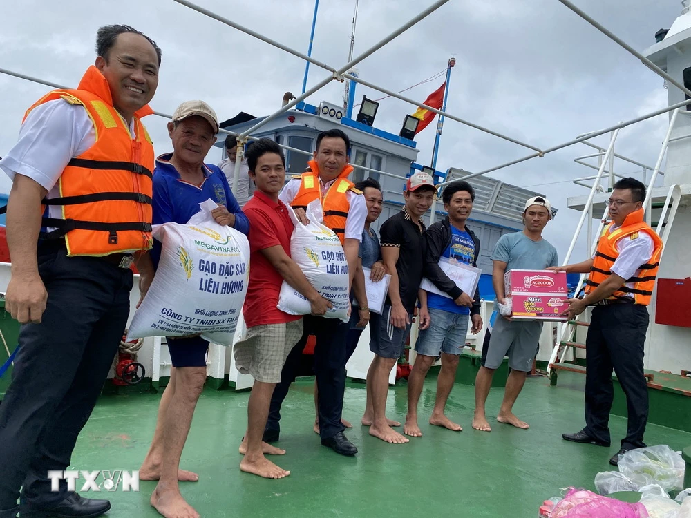 Các chiến sỹ hải quân công tác trên huyện đảo Trường Sa hỗ trợ lương thực, thực phẩm cho ngư dân Bình Thuận. (Ảnh: TTXVN phát)