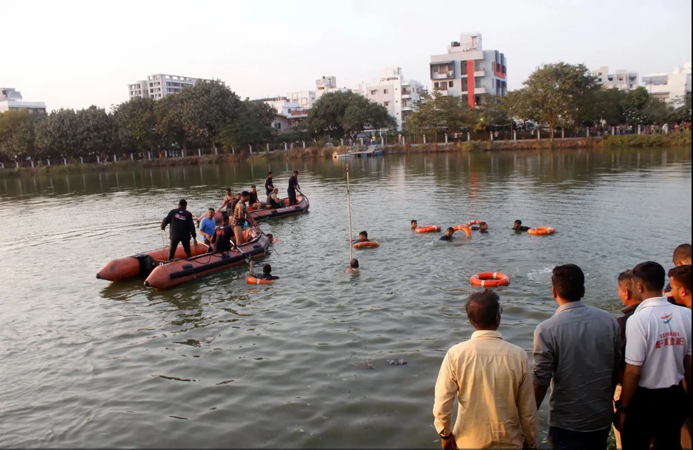 Lực lượng cứu hộ tìm kiếm học sinh mất tích sau khi chiếc thuyền chở 27 người bị lật ở bang Gujarat, miền Tây Ấn Độ, ngày 18/1. (Nguồn: AP)
