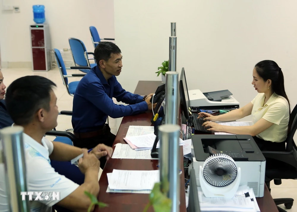 Người dân đến làm thủ tục hành chính tại khu vực của Sở Tài Nguyên và Môi trường ở Trung tâm hành chính công tỉnh Lai Châu.( Ảnh: Quý Trung/TTXVN)