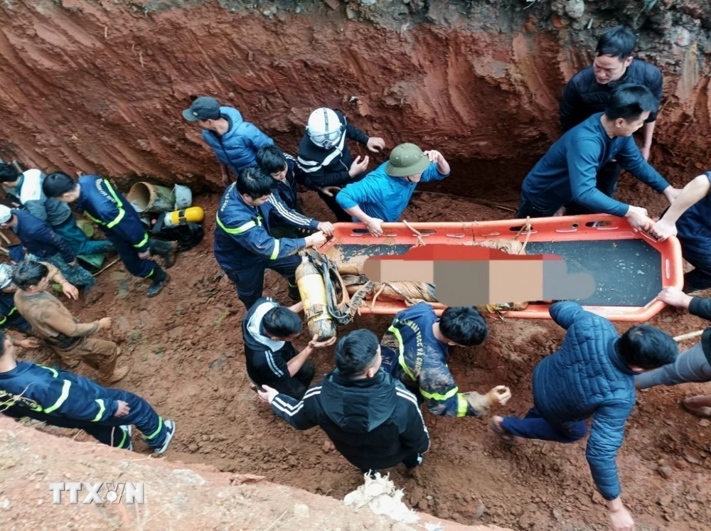 Lực lượng chức năng triển khai công tác cứu nạn cứu hộ đưa nạn nhân lên mặt đất. (Ảnh TTXVN phát)