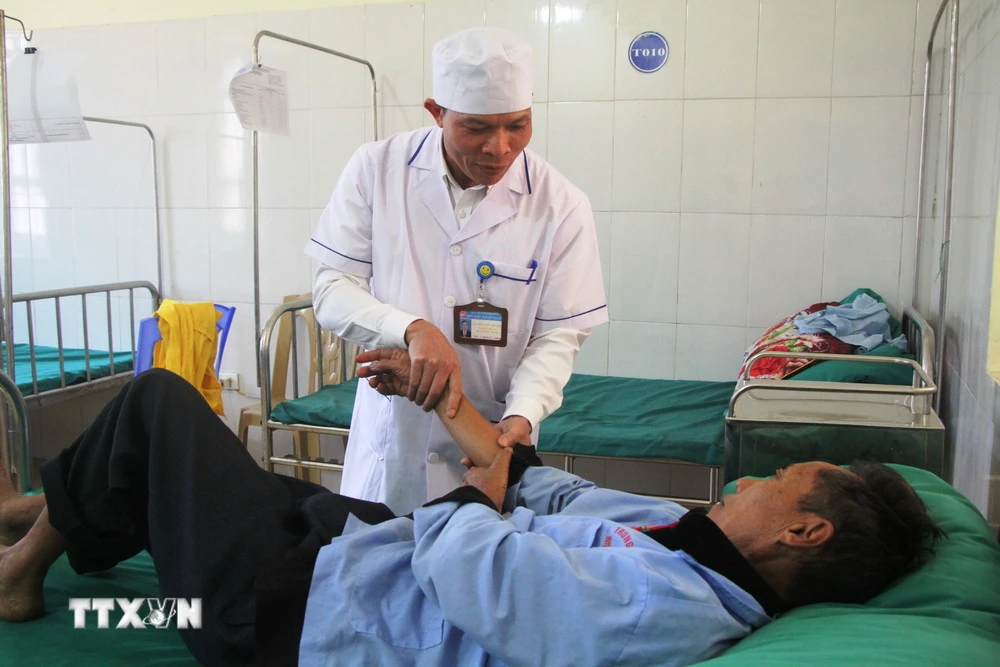 Điều dưỡng Mào Văn Hương chăm sóc sức khỏe cho bệnh nhân tại Trung tâm Y tế huyện Tủa Chùa, tỉnh Điện Biên. (Ảnh: Phan Quân/TTXVN)