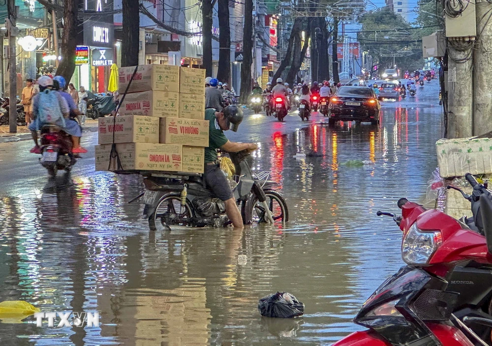 Người dân gặp khó khăn khi di chuyển do nước ngập trên đường Nguyễn Trãi, quận Ninh Kiều, thành phố Cần Thơ. (Ảnh: Thanh Liêm/TTXVN)