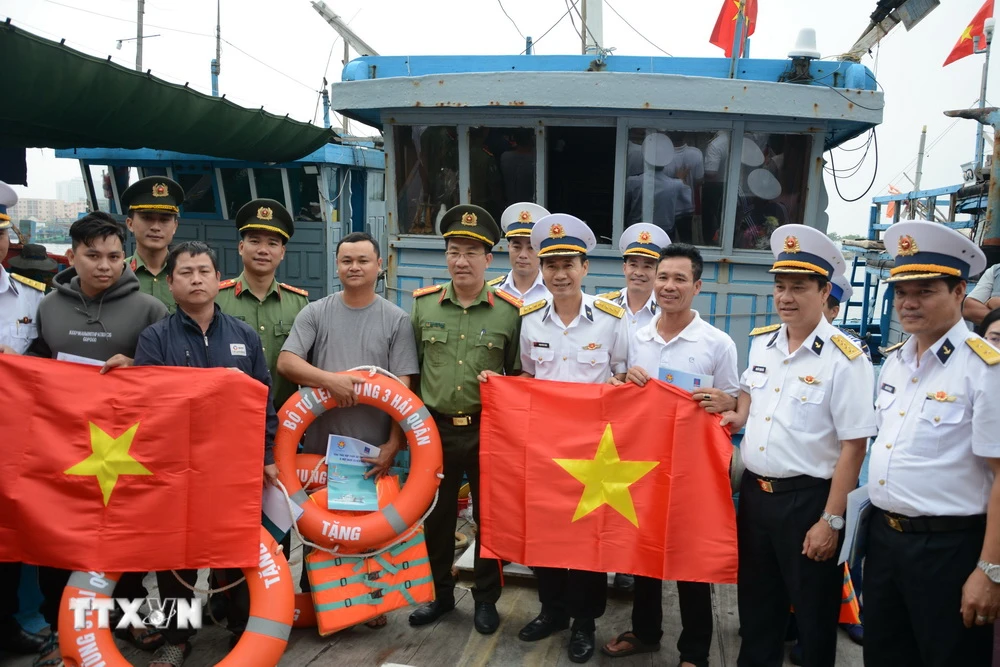 Bộ Tư lệnh Vùng 3 Hải quân tặng quà và cờ tổ quốc cho ngư dân Âu thuyền Thọ Quang. (Ảnh: Văn Dũng/TTXVN)