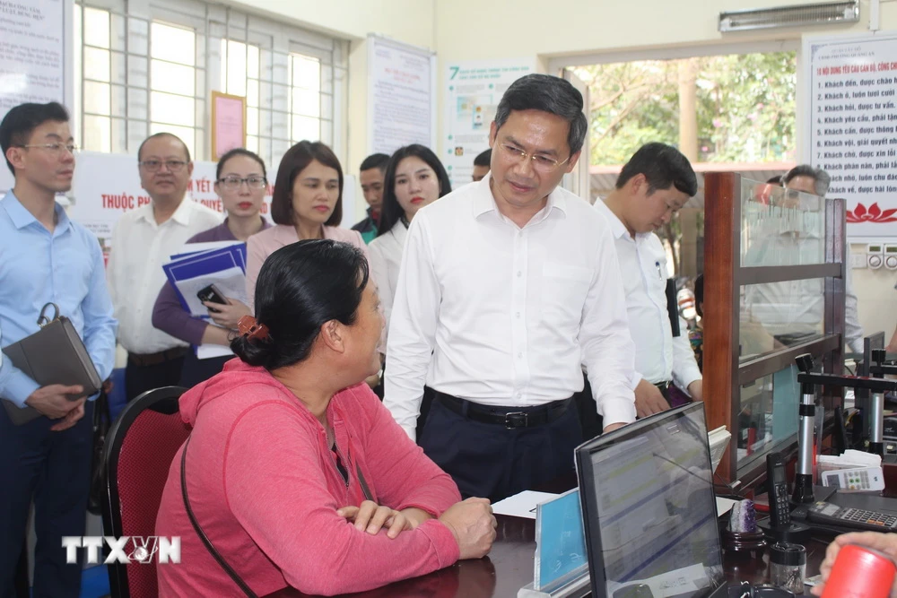Phó Chủ tịch UBND thành phố Hà Nội Hà Minh Hải trao đổi với người dân làm thủ tục hành chính tại UBND phường Quảng An, quận Tây Hồ. (Ảnh: Nguyễn Thắng/TTXVN)
