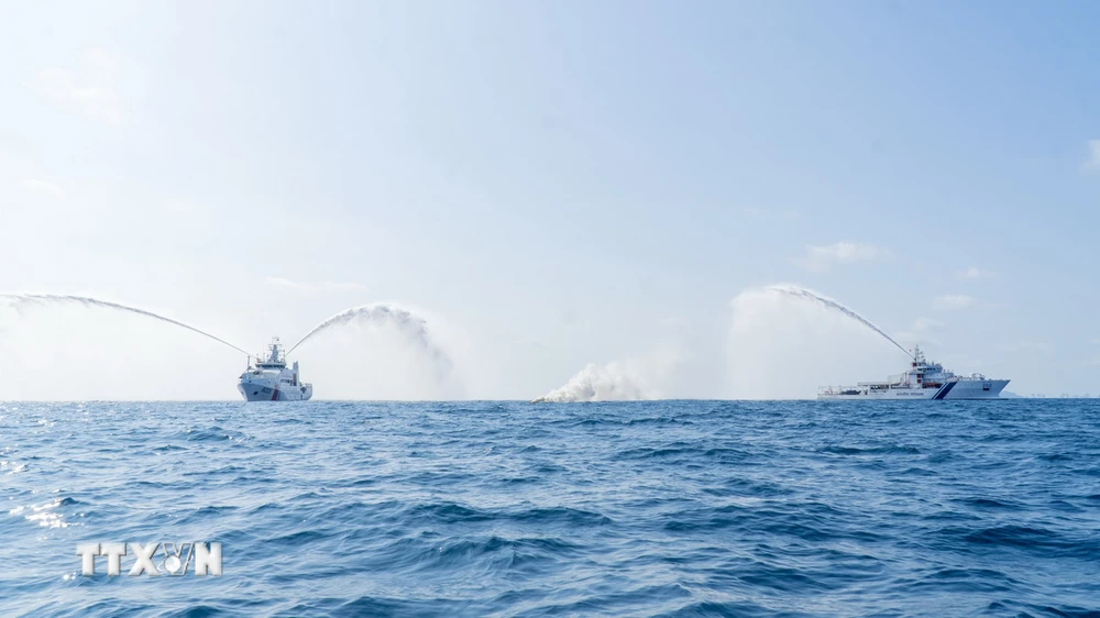 Tàu CSB 8005 thuộc Bộ Tư lệnh Vùng Cảnh sát biển 3 và tàu Sumadra Paheredar-ICG 202 của Lực lượng Bảo vệ bờ biển Ấn Độ tiến hành hiệp đồng phun vòi rồng dập tắt đám cháy trên biển. (Ảnh: Huỳnh Sơn/TXVN)