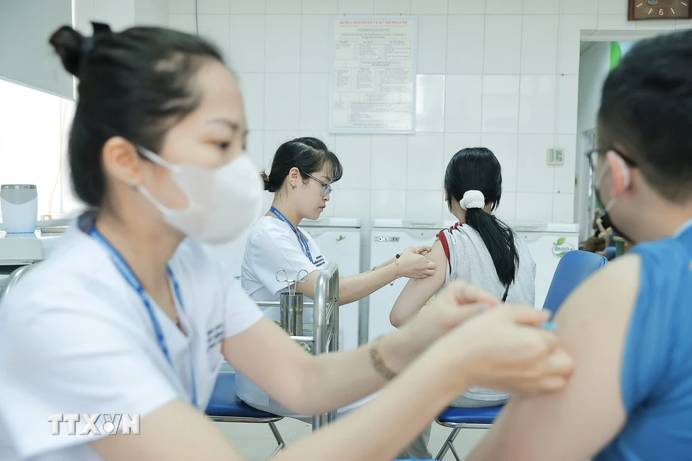 Nhân viên y tế tiêm vaccine phòng bệnh cho người dân tại Trung tâm Kiểm soát bệnh tật Hà Nội. (Ảnh: Minh Quyết/TTXVN)