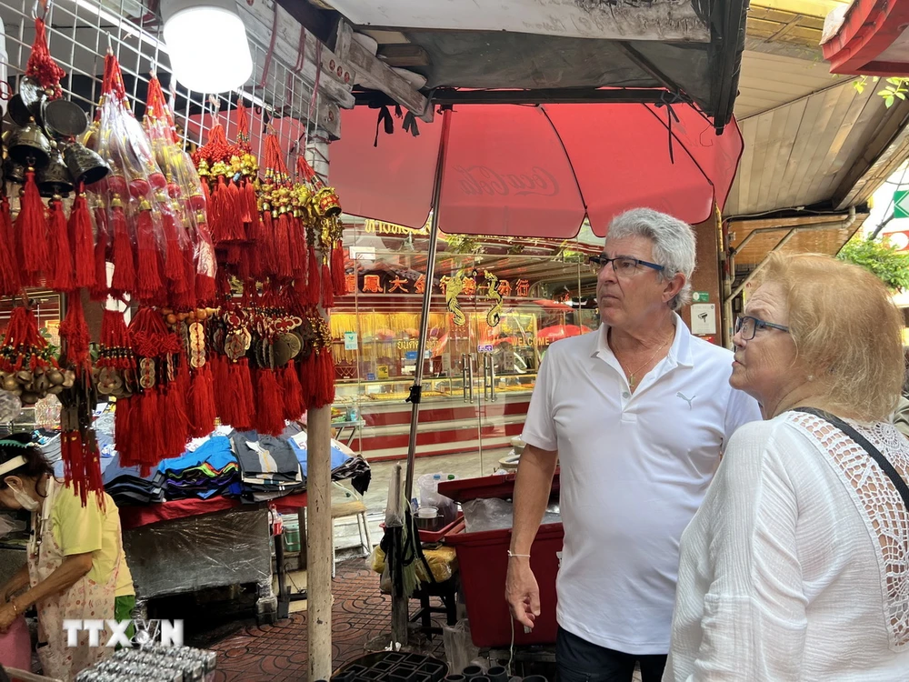 Khách du lịch nước ngoài trước hàng bán đồ trang trí Tết tại khu Chinatown ở Bangkok. (Ảnh: Đỗ Sinh/TTXVN)