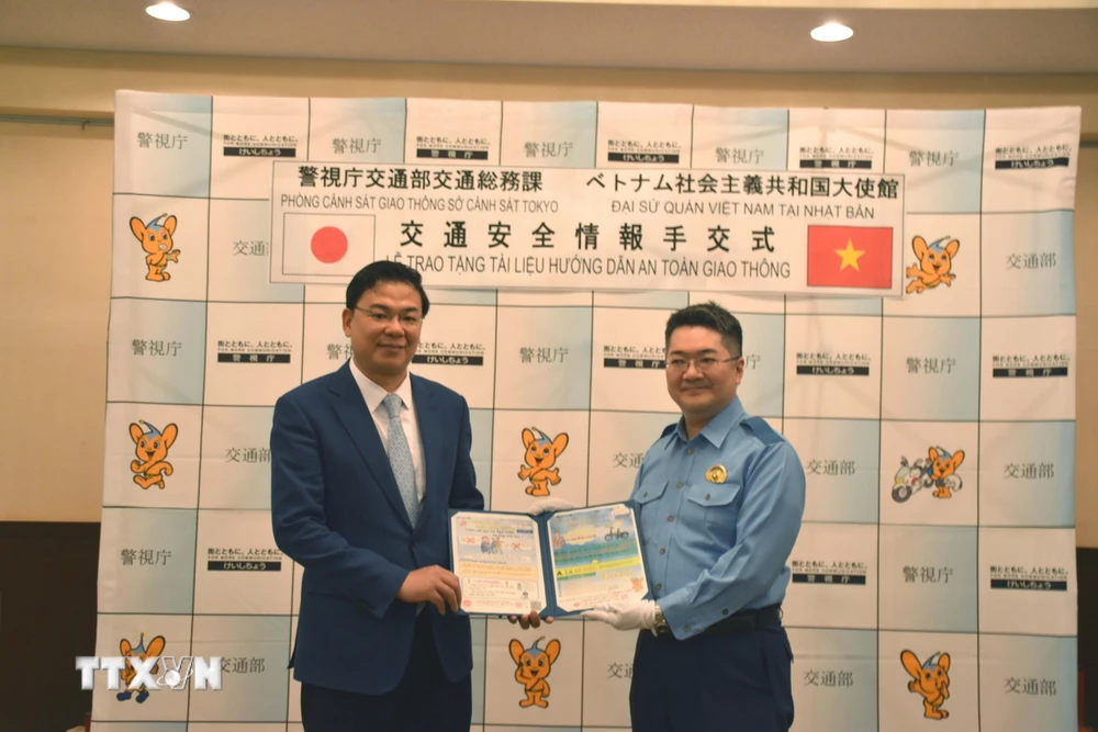 Đại diện Sở Cảnh sát Tokyo đã trao tặng Tài liệu hướng dẫn an toàn giao thông cho Đại sứ Việt Nam tại Nhật Bản Phạm Quang Hiệu. (Ảnh: Nguyễn Tuyến/TTXVN)