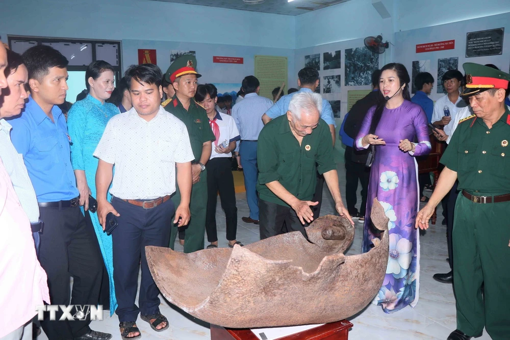 Các cựu chiến binh xem một miếng bom được trưng bày tại “Huyền thoại Trường Sơn.” (Ảnh: Đoàn Hữu Trung/TTXVN)