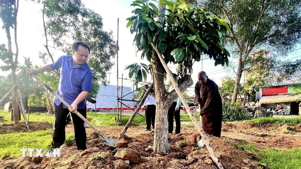 Lãnh đạo Thành ủy, UBND thành phố Thủ Dầu Một, tỉnh Bình Dương tham gia trồng cây ăn quả phủ xanh đất công để tạo công viên. (Ảnh: TTXVN phát)