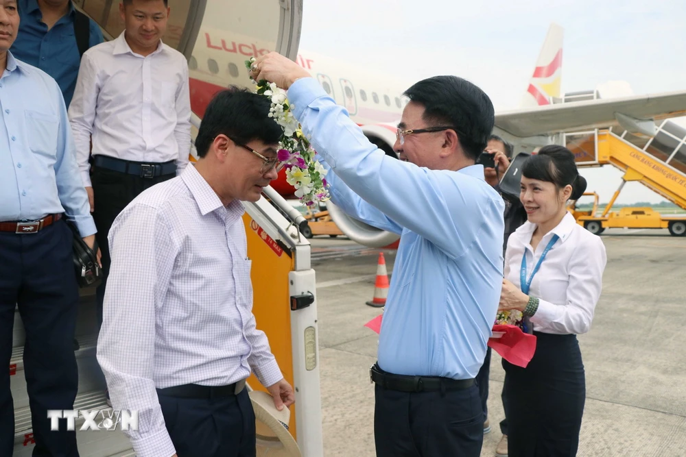 Ông Lê Khắc Nam, Phó Chủ tịch UBND thành phố Hải Phòng tặng hoa hành khách chuyến bay đầu tiên khởi hành từ Lệ Giang, tỉnh Vân Nam, Trung Quốc, đã hạ cánh tại Cảng Hàng không Quốc tế Cát Bi, thành phố Hải Phòng. (Ảnh: Hoàng Ngọc/TTXVN)