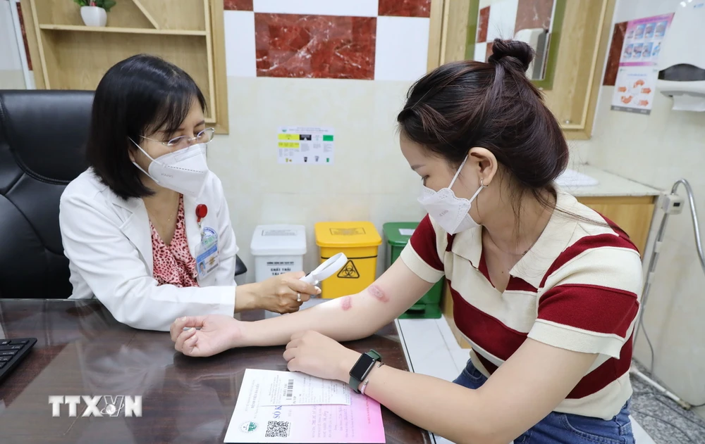Bác sỹ Bệnh viện Da liễu Thành phố Hồ Chí Minh khám bệnh cho người dân bị viêm da do độc tố của kiến ba khoang. (Ảnh: TXVN phát)