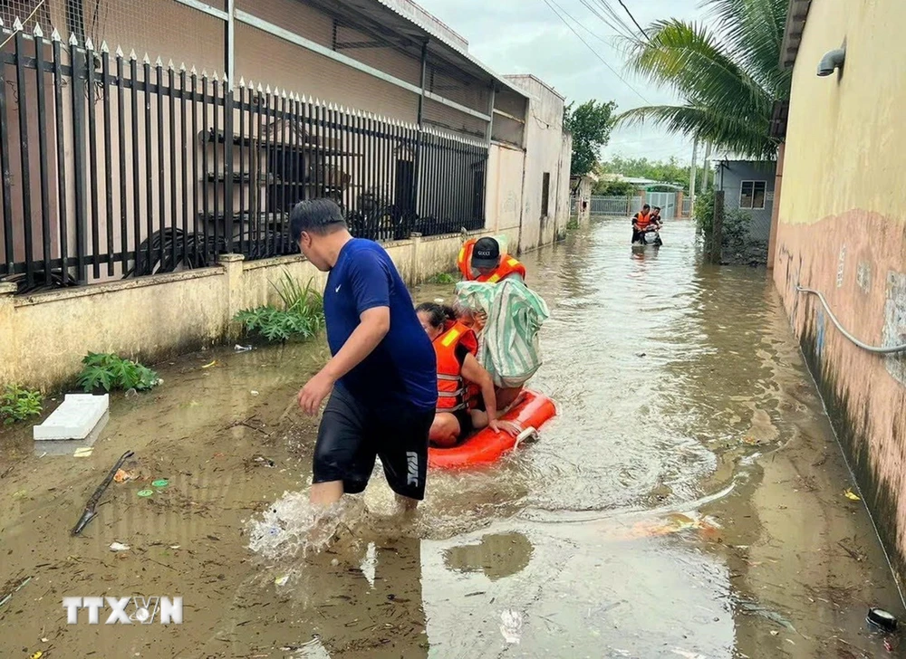 Cán bộ, chiến sỹ Ban Chỉ huy Quân sự thành phố Phú Quốc, tỉnh Kiên Giang, cùng với lực lượng địa phương ứng cứu, sơ tán người dân đến nơi an toàn do mưa lớn gây ngập cục bộ trên đảo. (Ảnh: TTXVN phát)