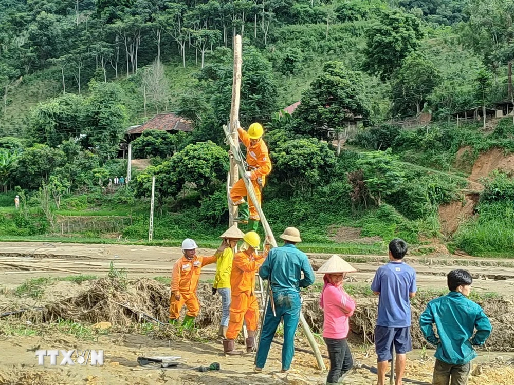 Công nhân Điện lực khu vực Mai Sơn-Yên Châu thuộc Công ty Điện lực Sơn La, nỗ lực khôi phục lại hệ thống điện cho 149 hộ dân bản Nhụng Trên, xã Chiềng Nơi. (Ảnh: TTXVN phát)