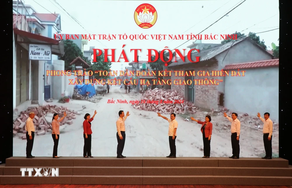 Các đại biểu nhấn nút phát động phong trào “Toàn dân đoàn kết tham gia hiến đất xây dựng kết cấu hạ tầng giao thông.” (Ảnh: Thanh Thương/TTXVN)