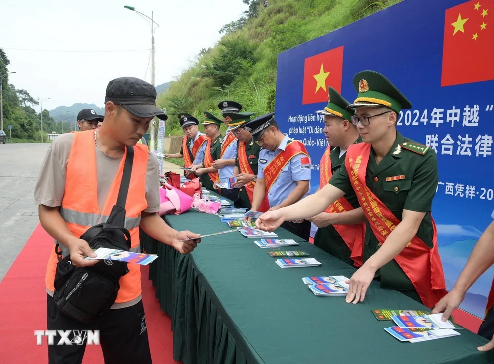 Cán bộ Đồn Biên phòng Tân Thanh, tỉnh Lạng Sơn, tuyên truyền, phát tờ rơi pháp luật biên giới tại cửa khẩu. (Ảnh: Quang Duy/TTXVN)