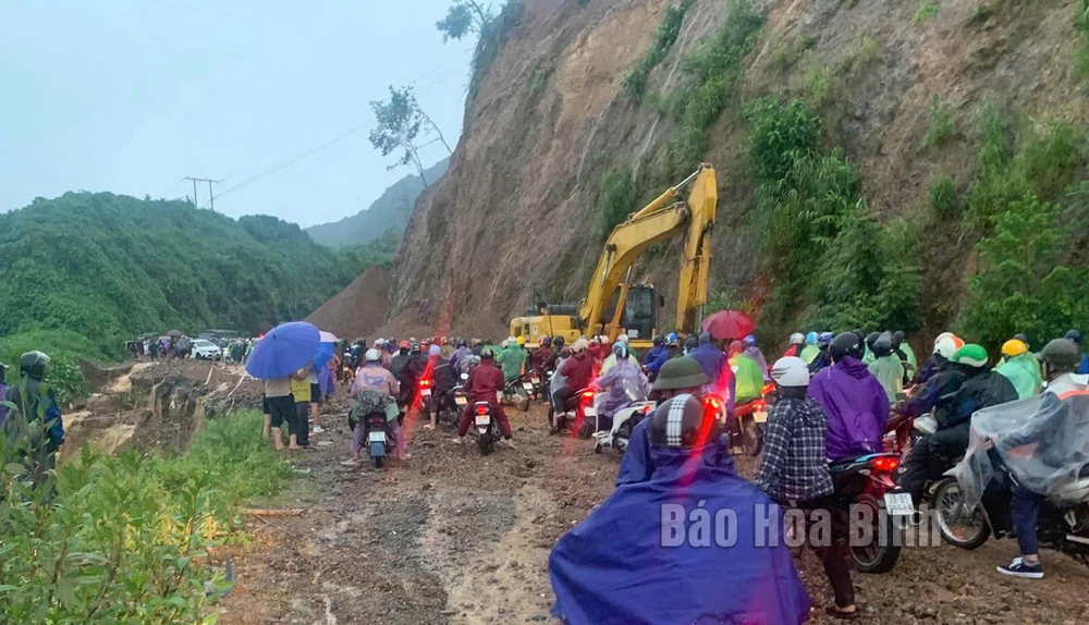 Lực lượng chức năng huy động phương tiện khắc phục sạt lở, hỗ trợ người dân lưu thông qua dốc Cun, tỉnh Hòa Bình. (Nguồn: báo Hòa Bình)