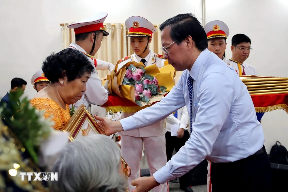 Chủ tịch UBND Thành phố Hồ Chí Minh Phan Văn Mãi truy tặng danh hiệu Mẹ Việt Nam Anh hùng cho 7 mẹ tại buổi lễ. (Ảnh: Thanh Vũ/TTXVN)