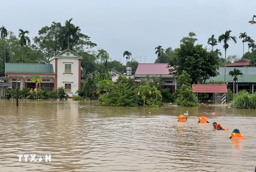 Lực lượng chức năng khẩn trương tiếp cận, di dời người dân và tài sản đến nơi an toàn. (Ảnh: Tạ Toàn/TTXVN)