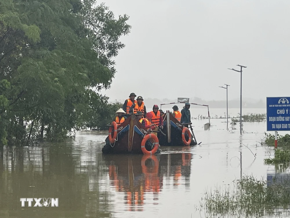 Các lực lượng chức năng di chuyển bằng thuyền hỗ trợ người dân vùng ngập lụt. (Ảnh: Thanh Thủy/TTXVN)