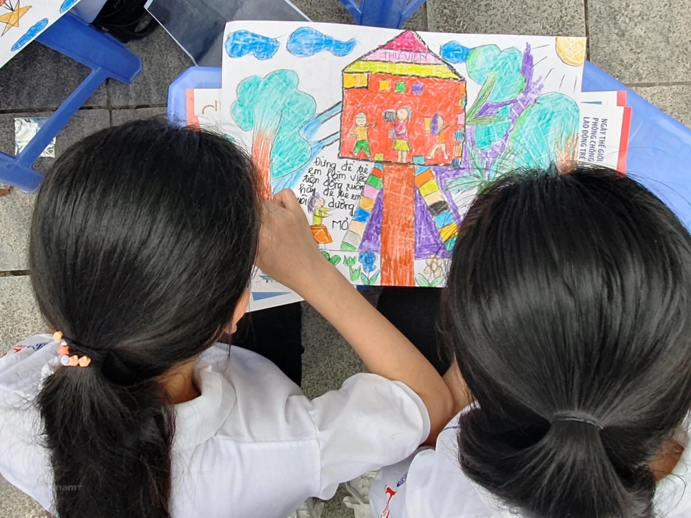Trẻ em tham gia vào sáng tác tranh với thông điệp ngăn chặn lao động trẻ em. (Ảnh: PV/Vietnam+)