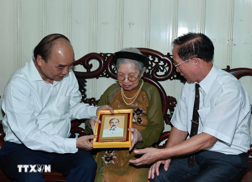 Chủ tịch nước Nguyễn Xuân Phúc đến thăm và tặng quà cho người có công. (Ảnh: Thống Nhất/TTXVN)