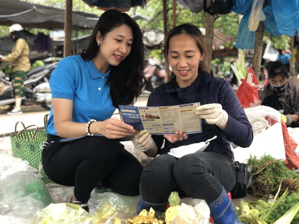 Tuyên truyền về chinh sách bảo hiểm xã hội tự nguyện cho người lao động. (Ảnh: PV/Vietnam+)