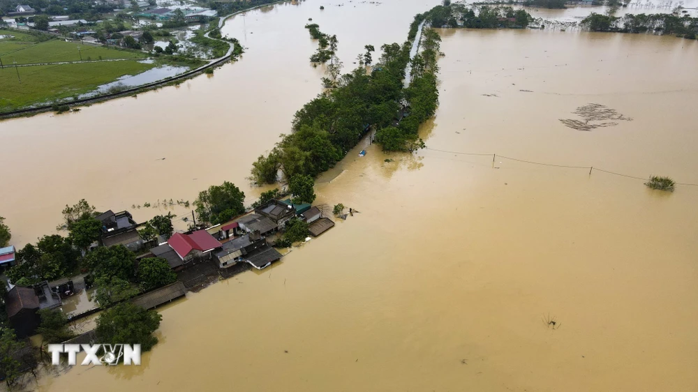 Đường vào thôn Nhân Lý (xã Nam Phương Tiến, huyện Chương Mỹ, Hà Nội) ngập chìm trong nước. Ảnh: Hoài Nam-TTXVN