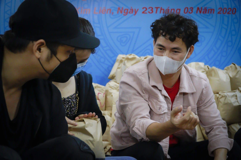 Nghệ sỹ Xuân Bắc cùng các diễn viên trẻ tham gia đóng gói những phần quà gửi tặng người khó khăn trong dịch bệnh. (Ảnh: Minh Hiếu/Vietnam+)