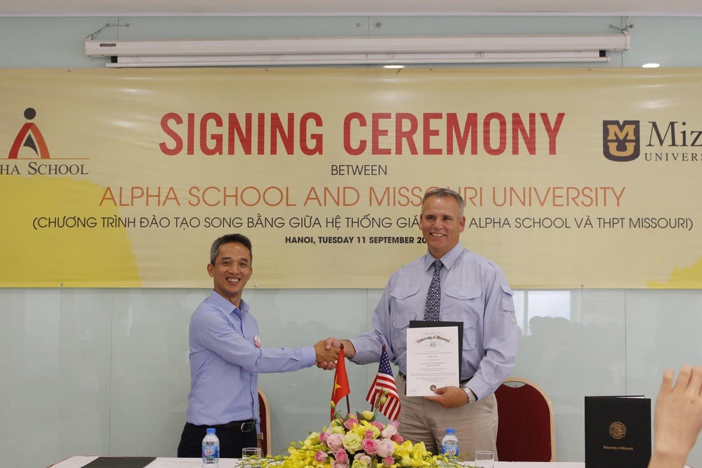 Đại diện IAE và Alpha School cùng ký kết thỏa thuận hợp tác đầu tư. (Ảnh: PV/Vietnam+)