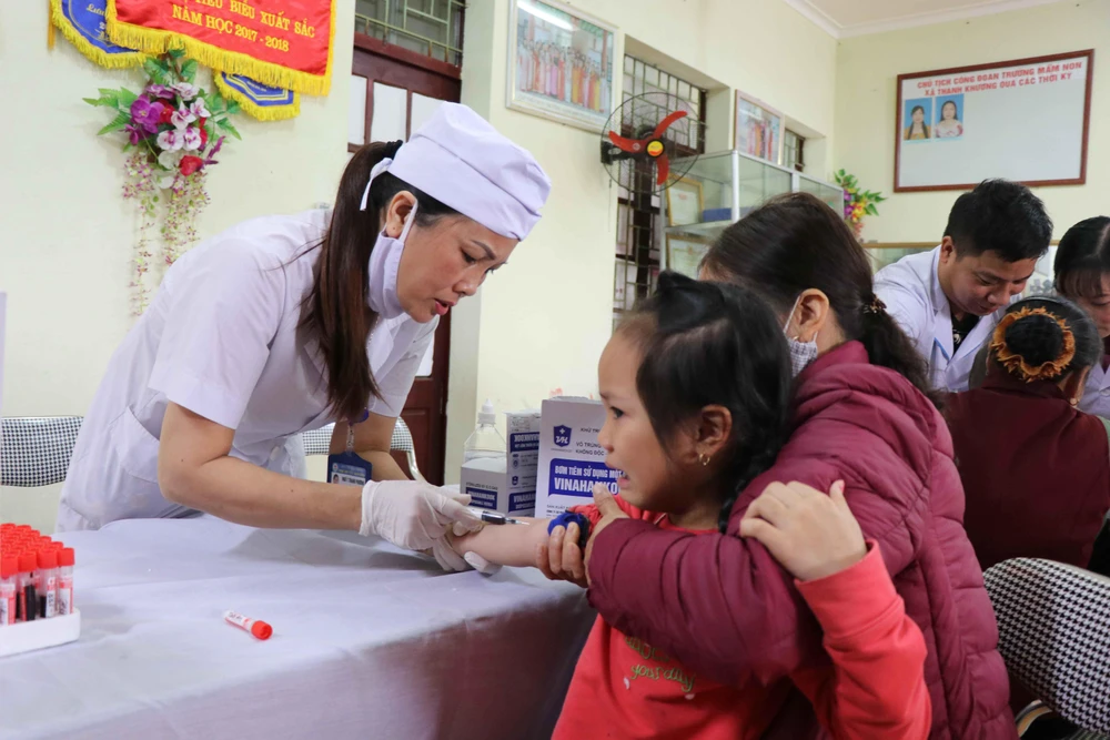 Cán bộ y tế tỉnh Bắc Ninh lấy mẫu máu xét nghiệm cho trẻ tại Trường Mầm non Thanh Khương. (Ảnh: Thanh Thương/Vietnam+)