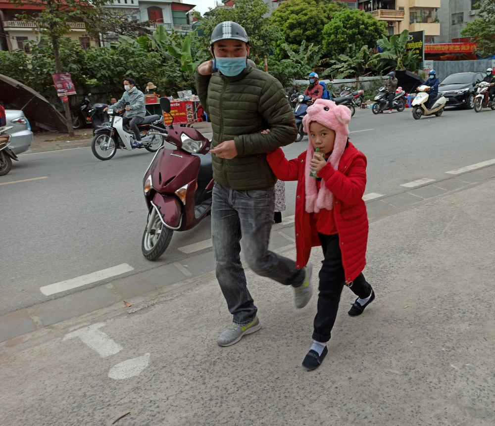 Học sinh Hà Nội đến trường trong giá rét. (Ảnh: PM/Vietnam+)