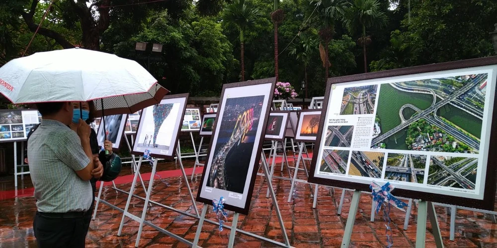 Dù trời mưa lớn, triển lãm ảnh vẫn thu hút đông đảo người xem. (Ảnh: Minh Thu/Vietnam+)