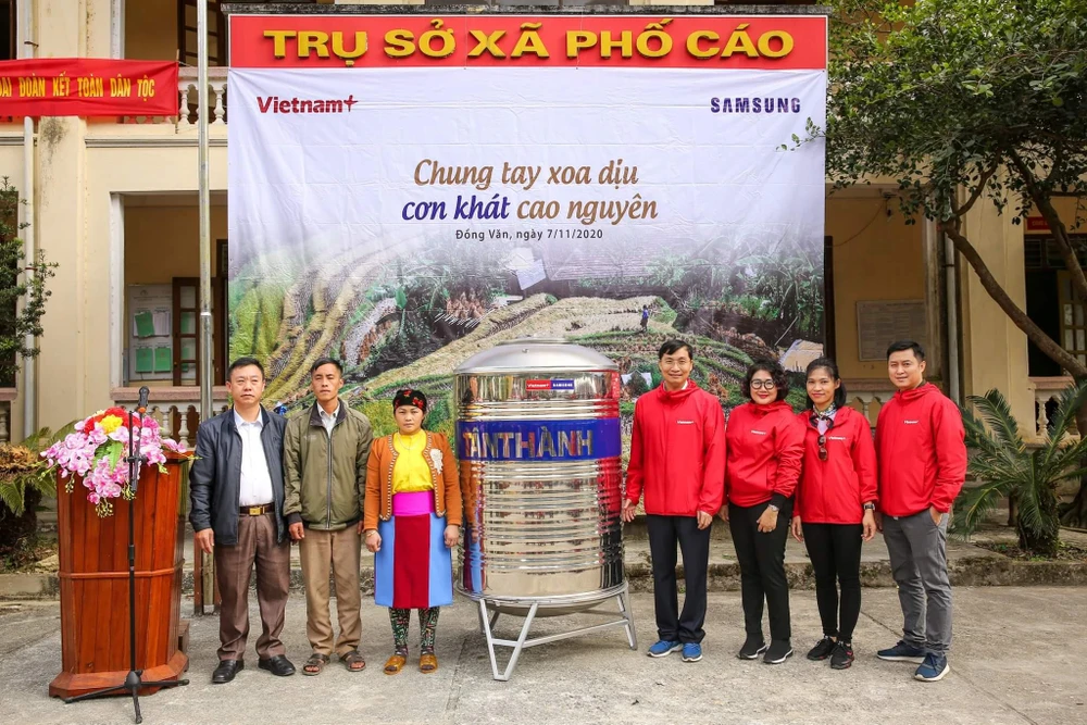 Đại diện Báo VietnamPlus trao tặng bồn chứa nước cho người dân thôn Sính Lủng. (Ảnh: Lê Minh Sơn/Vietnam+)