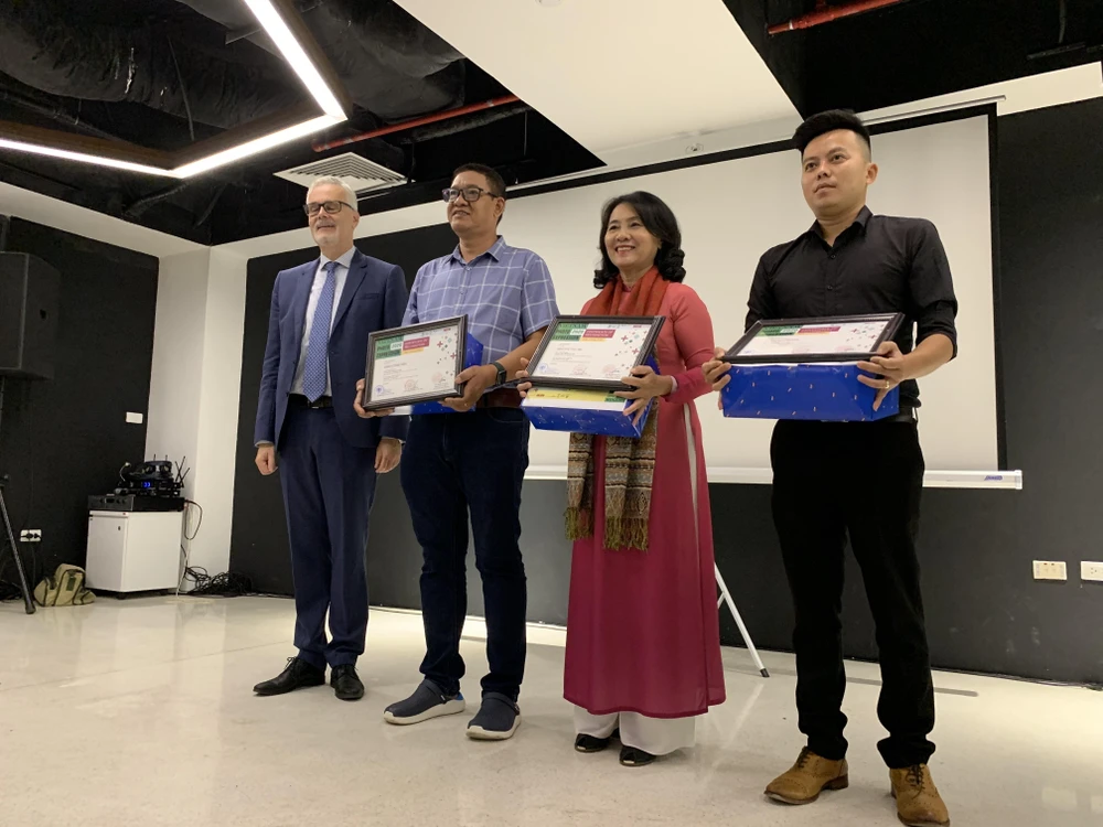 Đại sứ Cộng hòa Liên bang Đức tại Việt Nam Guido Hildner trao giải thưởng cho ba tác giả đoạt giải cao nhất của cuộc thi. (Ảnh: Nguyễn Đức/Vietnam+)