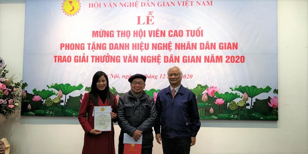 Tiến sỹ Lê Hồng Lý, Chủ tịch Hội Văn nghệ dân gian Việt Nam (phải) trao hai giải cao nhất cho các tác giả. (Ảnh: Minh Thu/Vietnam+)