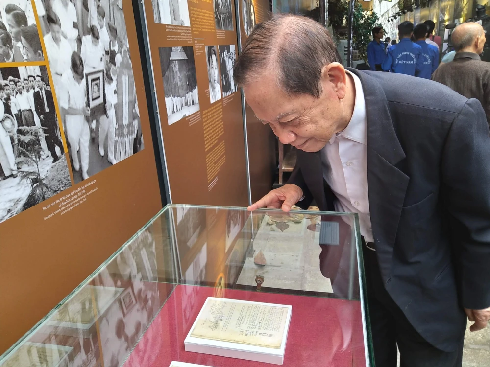 Ông Dương Tự Minh nhìn lại những trang báo Nhựa sống đang trưng bày tại Di tích Nhà tù Hỏa Lò. (Ảnh: Minh Thu/Vietnam+)