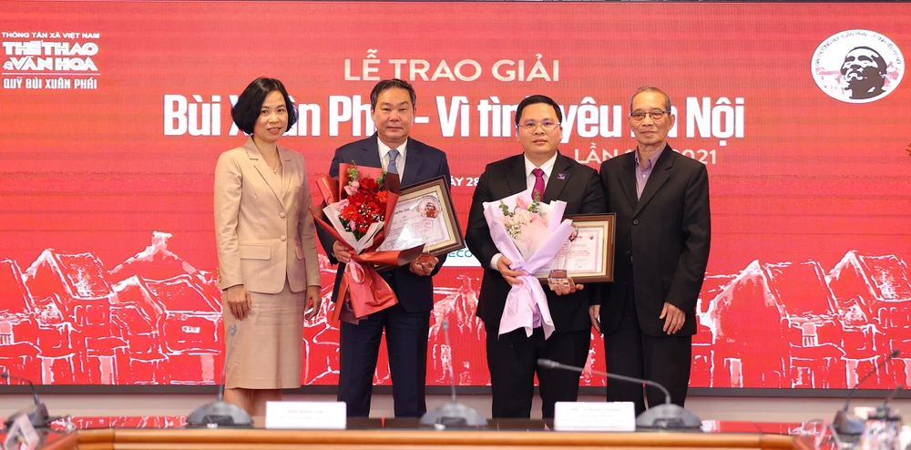 Nhà báo Vũ Việt Trang, Tổng giám đốc Thông tấn xã Việt Nam (trái) trao giải cho các tác giả. (Ảnh: PV/Vietnam+)
