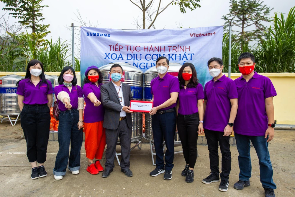 Lãnh đạo Báo Điện tử VietnamPlus trao tặng bình nước cho lãnh đạo xã Phố Cáo. (Ảnh: Minh Sơn/Vietnam+)