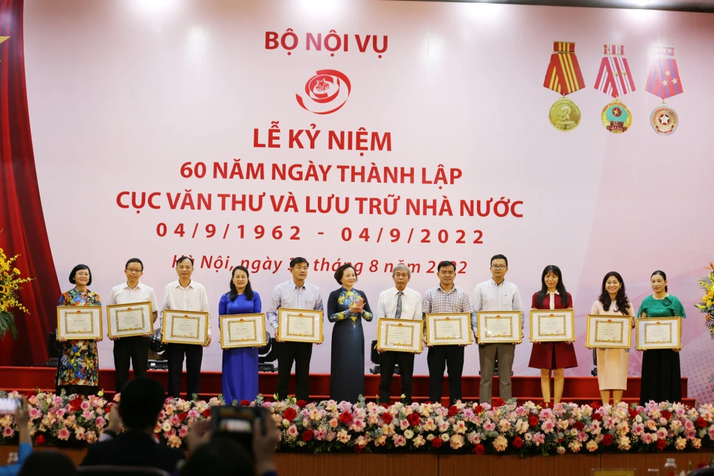 Bộ trưởng Bộ Nội vụ Phạm Thị Thanh Trà trao bằng khen cho các cá nhân có thành tích trong công tác lưu trữ. (Ảnh: PV/Vietnam+)