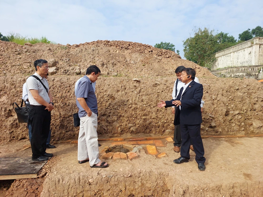 Phó giáo sư-tiến sỹ Tống Trung Tín, Chủ tịch Hội Khảo cổ học Việt Nam (bìa phải) cùng các chuyên gia bên một miệng giếng. (Ảnh: Minh Thu/Vietnam+)