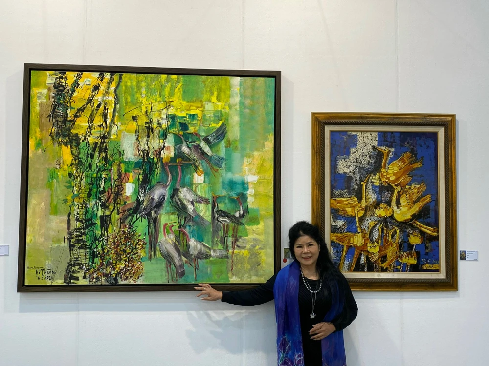 Họa sỹ Văn Dương Thành bên các tác phẩm của mình trong Triển lãm Nghệ thuật Quốc tế Daejeon. (Ảnh: PV/Vietnam+) 
