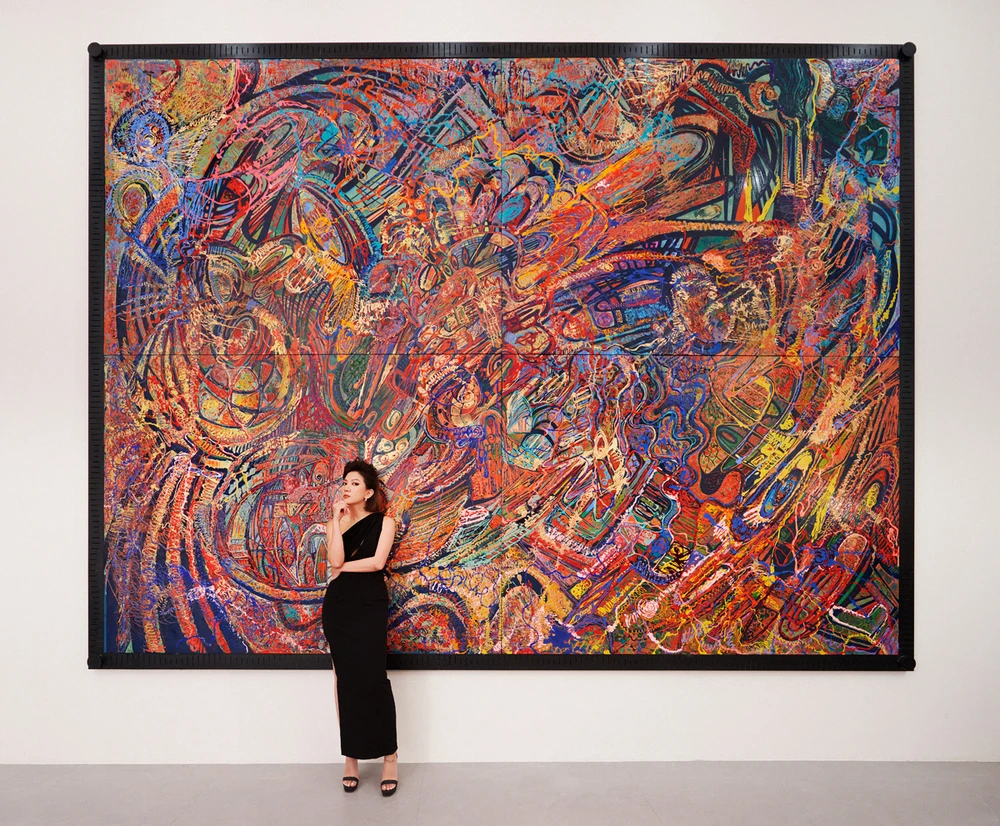 Họa sỹ CAT - Đào Anh Thơ với bức sơn mài nặng 250kg, tác phẩm đầu tiên trong series "Nước Mỹ bây giờ." (Ảnh: Lê Lai/Vietnam+ 